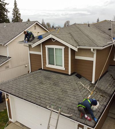 gutter cleaning professionals cleaning gutters on brown home